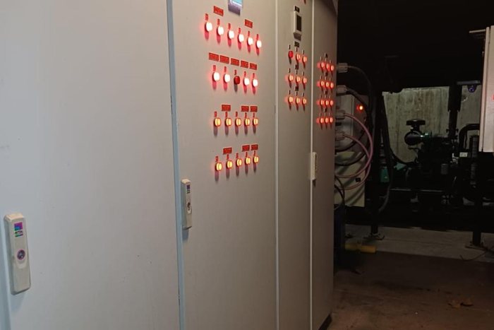 Técnico eléctrico con guantes trabajando en tablero eléctrico